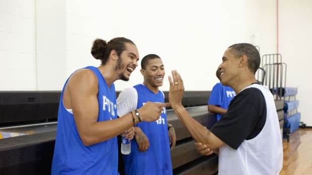 President Barack Obama jokes with  Chicago Bulls players Joakim Noah and Derrick Rose. The President played basketball with friends, college and professional basketball players, before an audience that included wounded warriors and White House mentees at Fort McNair in Washington, D.C., August 8, 2010. (Official White House Photo by Pete Souza) This official White House photograph is being made available only for publication by news organizations and/or for personal use printing by the subject(s) of the photograph. The photograph may not be manipulated in any way and may not be used in commercial or political materials, advertisements, emails, products, promotions that in any way suggests approval or endorsement of the President, the First Family, or the White House.