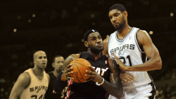 Miami Heat forward LeBron James drives to the basket against San Antonio Spurs forward Tim Duncan