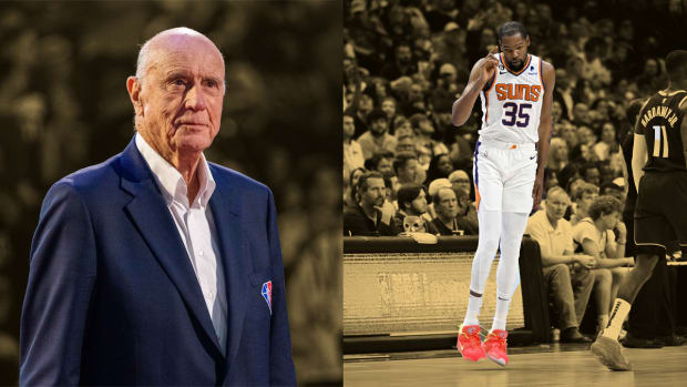 Bob Pettit signs a basketball during the Legends Portrait as part