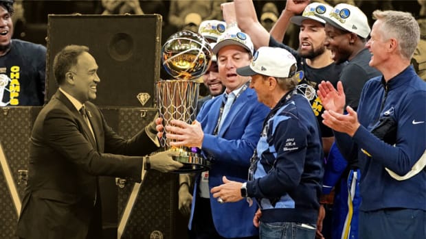 NBA deputy commissioner Mark Tatum hands the the Larry O'Brien Championship Trophy to Golden State Warriors owner Joseph Lacob after the Golden State Warriors beat the Boston Celtics in game six of the 2022 NBA Finals to win the NBA Championship at TD Garden