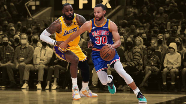 Golden State Warriors guard Stephen Curry dribbles past Los Angeles Lakers forward LeBron James