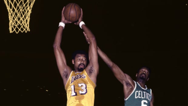 Los Angeles Lakers center Wilt Chamberlain grabs a rebound in front of Boston Celtics center Bill Russell