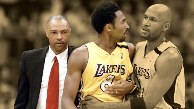 Los Angeles Lakers guard/forward Kobe Bryant is lead off the court by teammate Ron Harper (right) and assistant coach Jim Cleamons (left) 