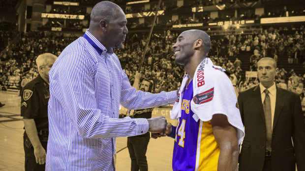 Former Houston Rockets center Hakeem Olajuwon talks with Los Angeles Lakers forward Kobe Bryant (24)