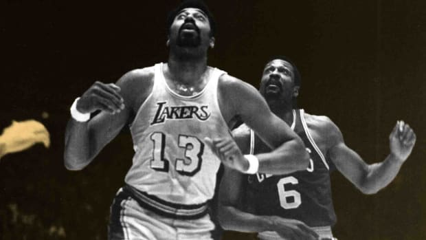 Los Angeles Lakers center Wilt Chamberlain (13) battles for a rebound in front of Boston Celtics center Bill Russell (6)
