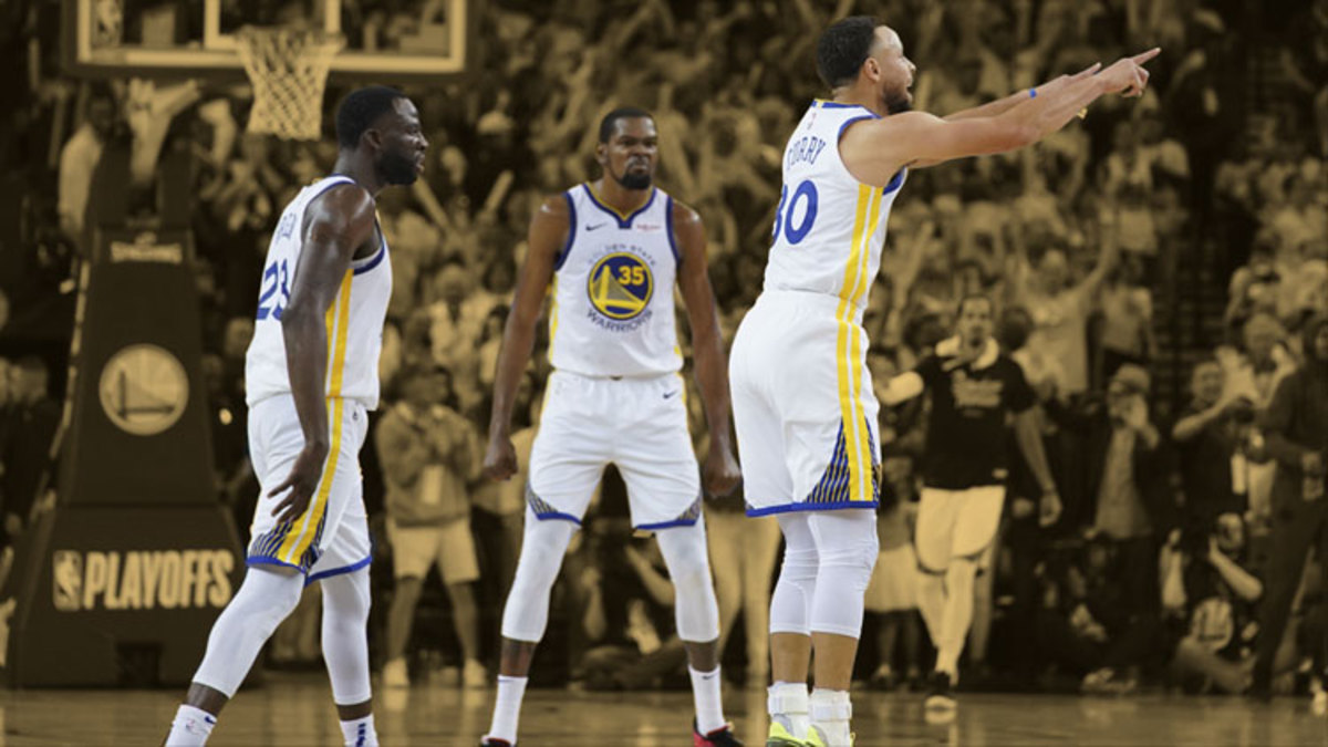Golden State Warriors guard Stephen Curry celebrates in front of forward Draymond Green and forward Kevin Durant